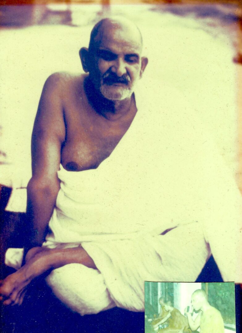 A man sitting on the ground wearing a towel.